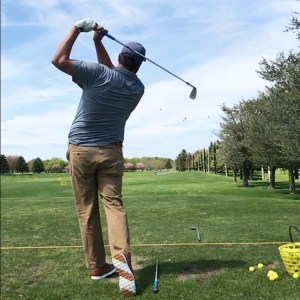 golfer swinging at the driving range